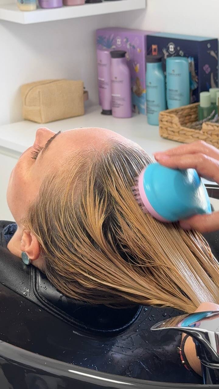 A repair mask worked into wet hair at the basin