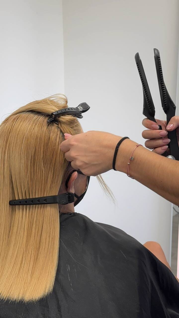 Blonde hair sealed with the iron during a keratin treatment